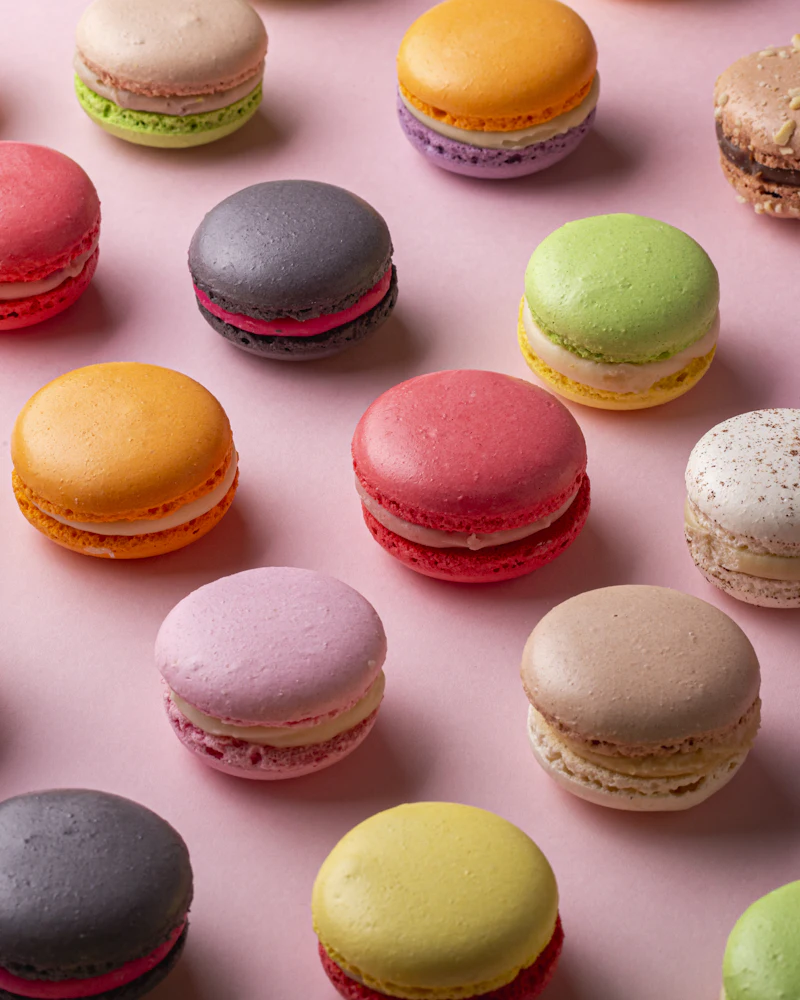 Macarons de colores sobre un fondo rosa