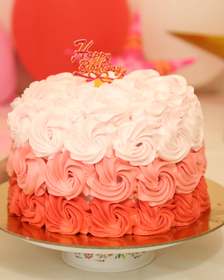 Torta con rosetas de crema en degradé de rosa