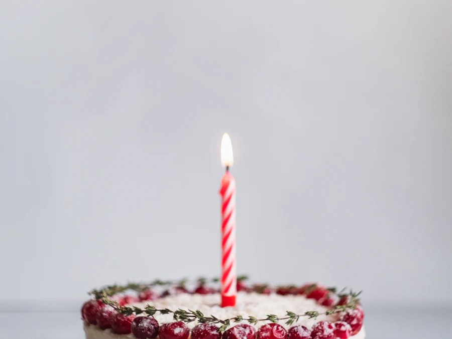 Torta blanca y rosa con una vela encendida